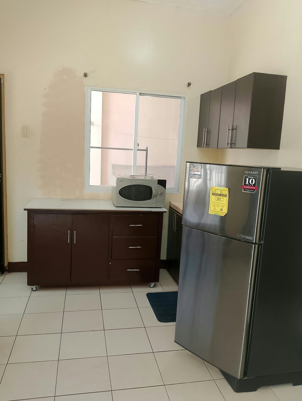 Kitchen with cabinets, refrigerator and microwave
